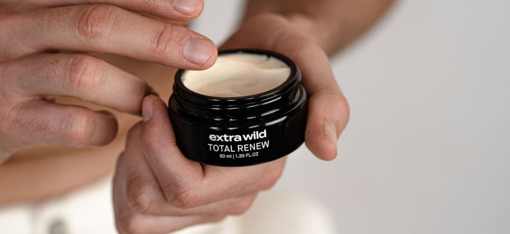 manos masculinas cogiendo un tarro de Total Renew Face Cream, crema hidratante